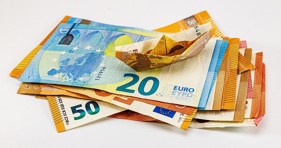 Eiro monētas un banknotes uz galda: nauda, likmes un nodokļi